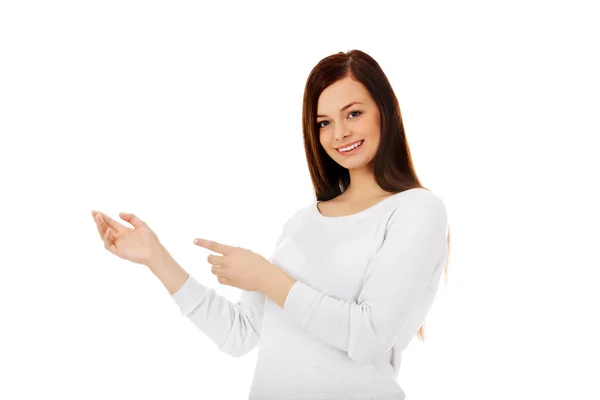 Sonriente joven mujer muestra algo —  Fotos de Stock