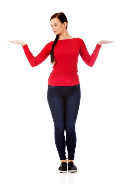 Young smiling woman presenting something on open palms — Stock Photo, Image