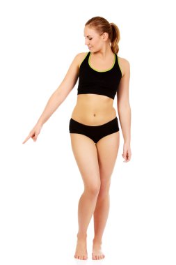 Boşaltmak veya bir şey için işaret eden genç atletik kadın