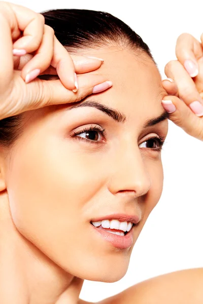 Worried young woman checking wrinkles on forehead — Stock Photo, Image