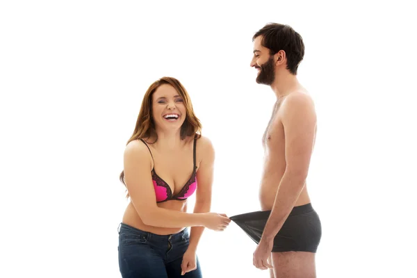 Amused woman looking into mans panties. — Stock Photo, Image