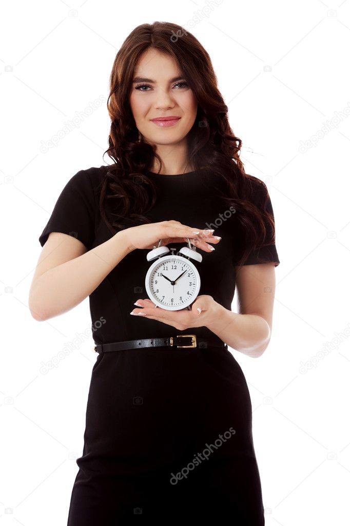 Happy young businesswoman holding alarm clock