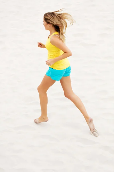 Junge Frau läuft am Strand — Stockfoto