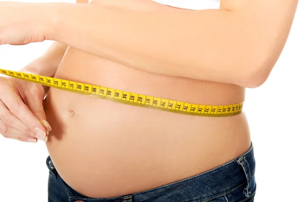 Mulher grávida medindo sua barriga crescente — Fotografia de Stock