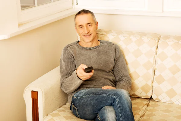 Mature man with remote control — Stock Photo, Image