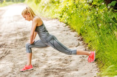 Genç bayan esniyor ve koşmaya hazırlanıyor..