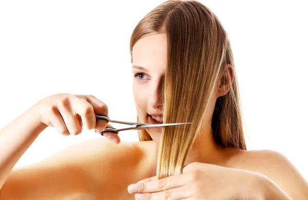 Young blonde woman cutting her hair with scissors. — Stock Photo, Image