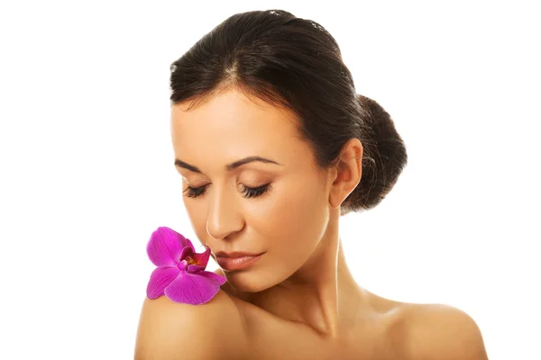 Mulher com pétala de orquídea roxa no ombro — Fotografia de Stock