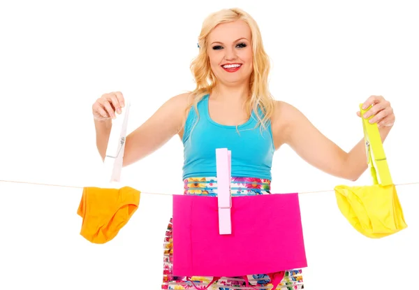 Young woman hanging laundry with huge clothespin — Stock Photo, Image