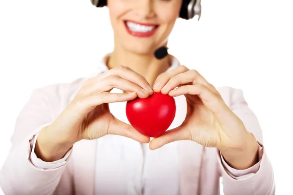 Feliz call center mulher segurando coração brinquedo — Fotografia de Stock