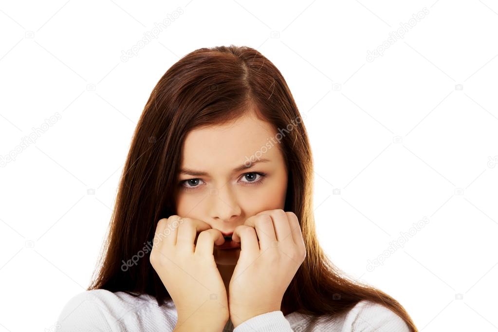 Young stressed woman biting her nails