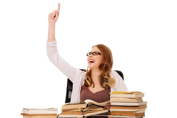 Giovane donna con libri mucchio che punta verso l'alto — Foto Stock