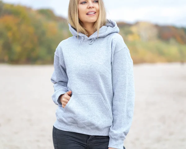 Vrouw draagt hoodie op het strand — Stockfoto