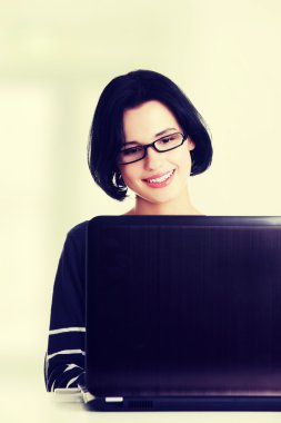 Dizüstü bilgisayarını kullanan mutlu genç kadın.