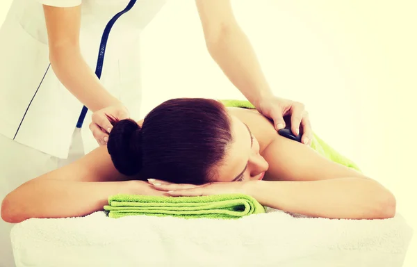 Mulher bonita deitada no salão de spa com massagem de pedra . — Fotografia de Stock