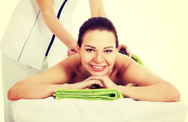 Bella donna sdraiata sul salone spa con massaggio in pietra . — Foto Stock