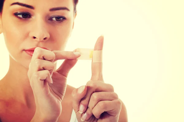 Beautiful woman with plaster on her finger. — Stock Photo, Image