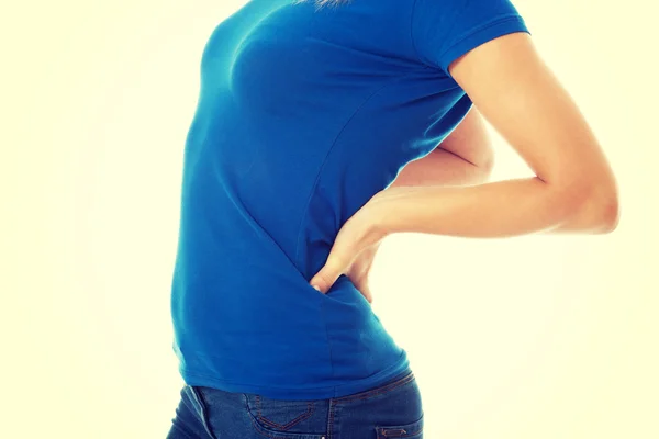 Mujer casual joven está teniendo un dolor de espalda . — Foto de Stock