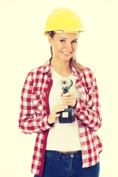 Mujer casual joven sosteniendo taladro y usando casco de seguridad . — Foto de Stock