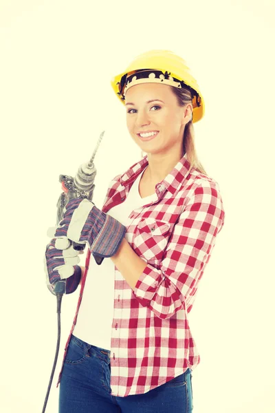 Young casual woman holding drill and wearing safety helmet. — Stock Photo, Image