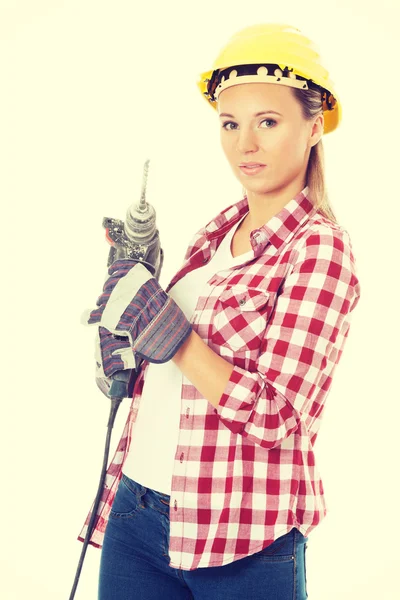 Casual jongedame bedrijf boor en dragen veiligheidshelm. — Stockfoto