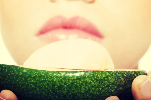 Close up on avocado hel by a beautiful woman. — Stock Photo, Image