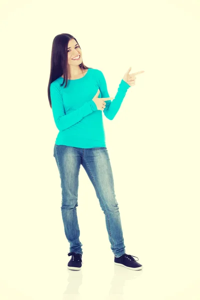Vackra casual kvinna som pekar på kopia utrymme. — Stockfoto