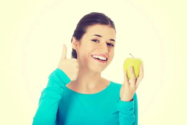 Porträt einer schönen Frau, die ok mit Apfel zeigt. — Stockfoto