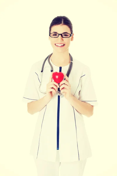 Beautiful young female doctor holding a heart. — Stock Photo, Image