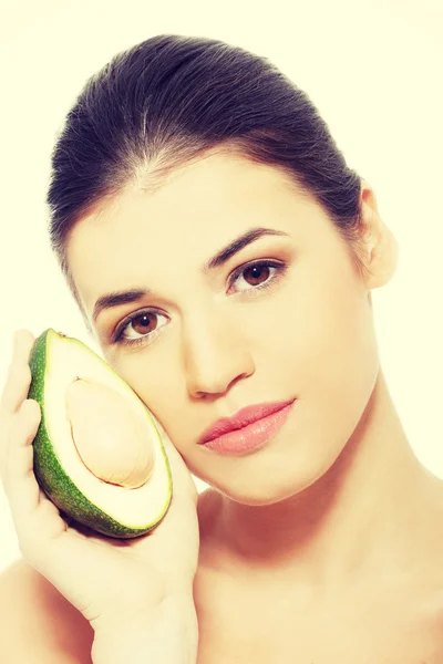 Beautiful womans face with avocado. — Stock Photo, Image