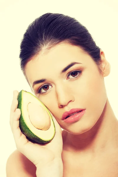 Beautiful womans face with avocado. — Stock Photo, Image