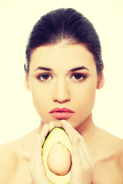 Beautiful womans face with avocado. — Stock Photo, Image