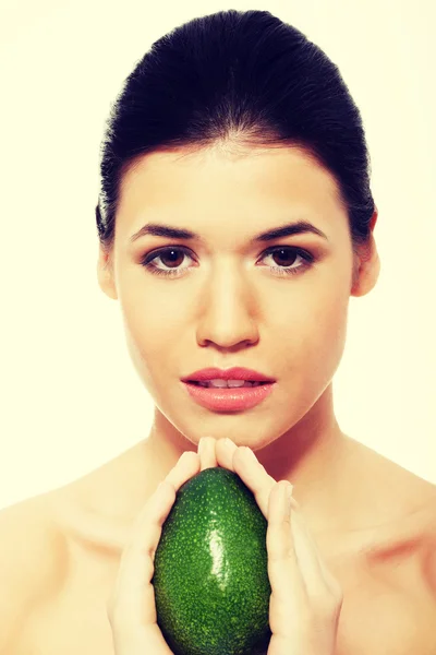 Beautiful womans face with avocado. — Stock Photo, Image