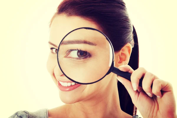 Young beautiful woman with magnifying glass. — Stock Photo, Image