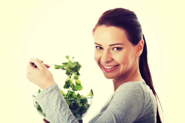 Junge Gelegenheitsfrau isst Feldsalat. — Stockfoto