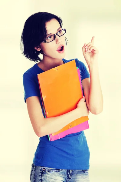 Mulher estudante com nota colorida pad apontando para cima . — Fotografia de Stock