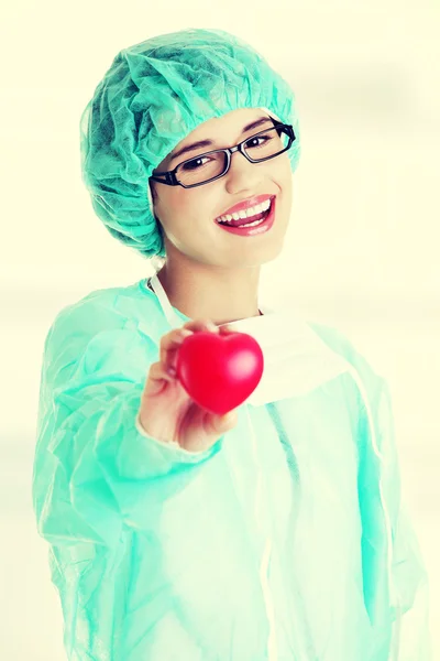 Médica sorridente ou enfermeira segurando o coração — Fotografia de Stock