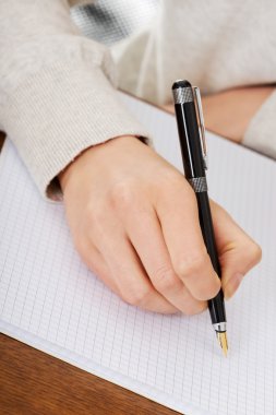 el ile bir defter kalem yazıyor.