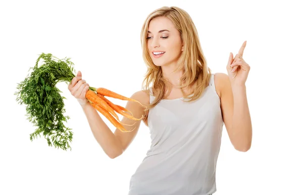 Молодая женщина с морковкой — стоковое фото