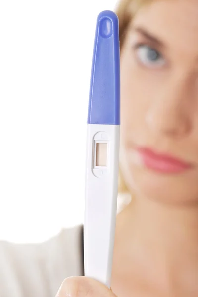 Sad young woman holding pregnancy test — Stock Photo, Image