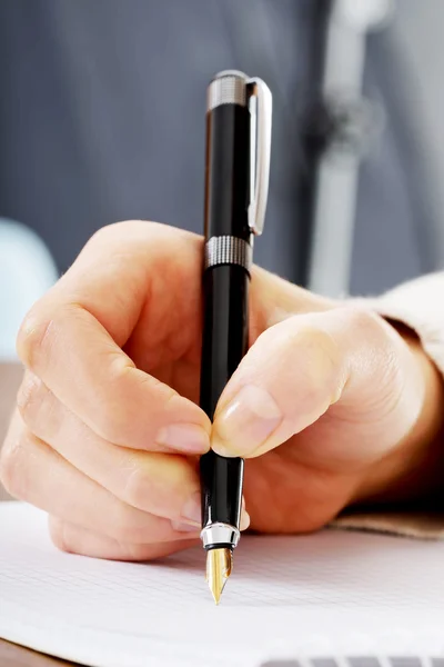 Hand schrijft met een pen in een notitieblok — Stockfoto