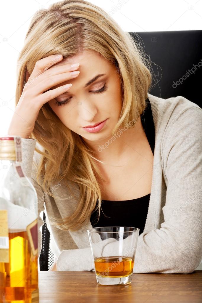 Yound woman in depression, drinking alcohol