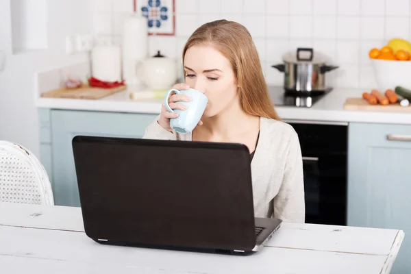 Jeune femme utilisant un ordinateur portable à la maison — Photo