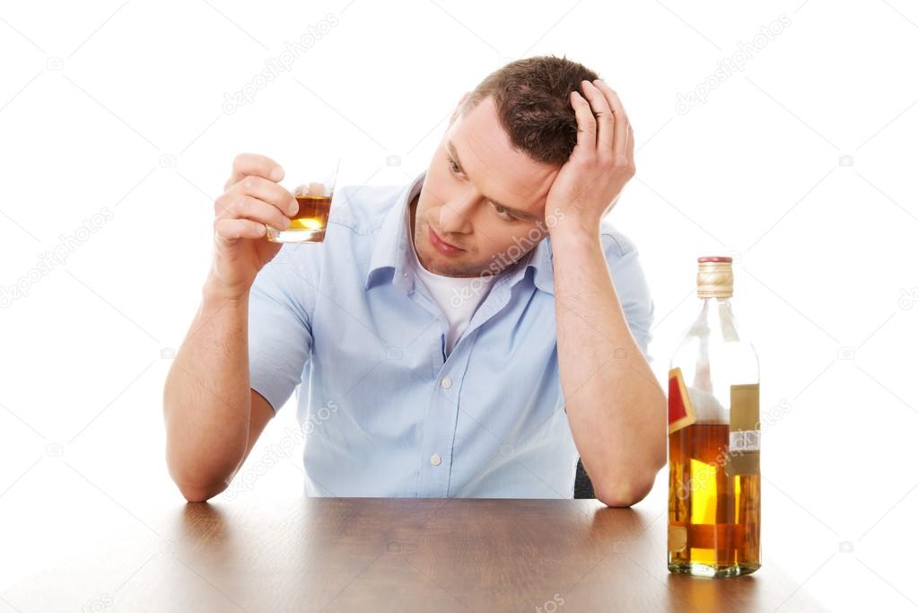 Yound man in depression, drinking alcohol