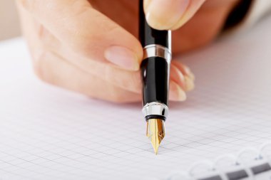 el ile bir defter kalem yazıyor.