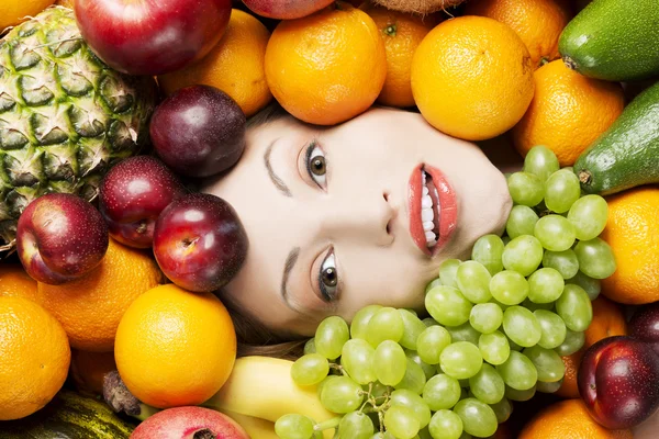 Young woman in group of fruit. — Stock Photo, Image