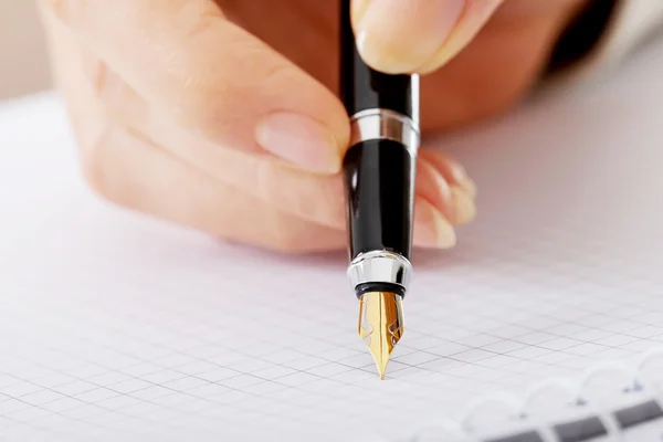 Ręka pisze piórem w notatniku — Zdjęcie stockowe