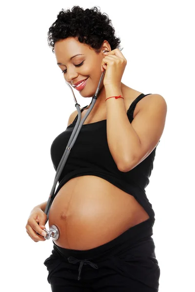 Pregnant  woman with stethoscope listening to baby — Stock Photo, Image