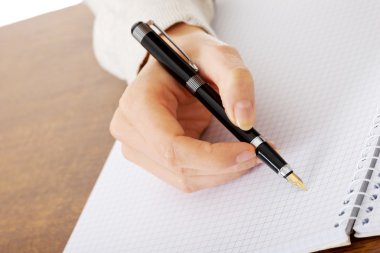 el ile bir defter kalem yazıyor.
