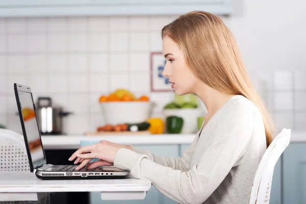 Mujer joven usando una computadora portátil en casa — Foto de Stock